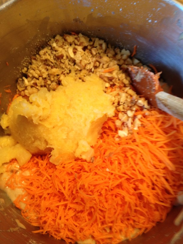 Carrots, pineapple and nuts folding into the cake batter