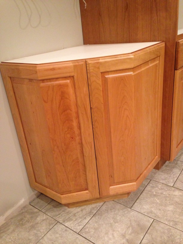 Corner cabinet swings open from middle