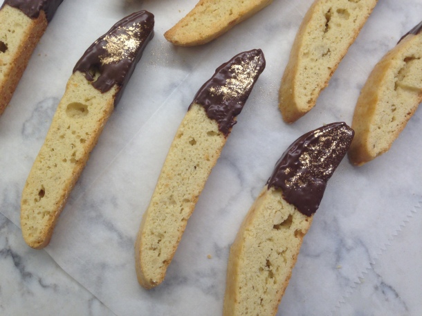 Almond biscotti brushed with dark chocolate and dusted with gold