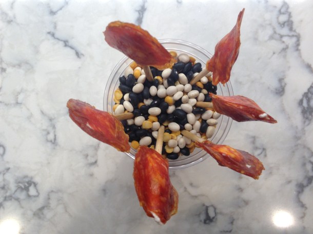 Lollipops stand up in a cup of dried beans