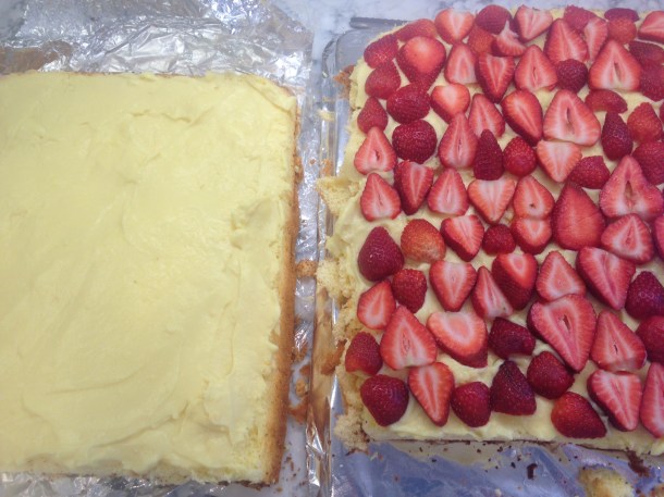 Cake sliced in half and spread with custard and covered with fresh strawberries